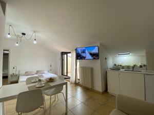 a kitchen and living room with a table and a tv at ATTICO con TERRAZZO panoramico MAIELLA - 1piano - VASTO in Vasto