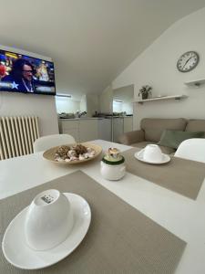 a kitchen and living room with a table with white plates at ATTICO con TERRAZZO panoramico MAIELLA - 1piano - VASTO in Vasto +5 photos