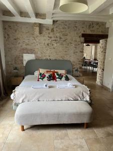 ein Schlafzimmer mit einem großen Bett in einer Steinmauer in der Unterkunft La Maison de Zoé in Saint-Denis-sur-Loire + 28 Fotos