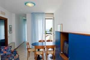 a living room with a table and chairs and a television at Residence Oltremare in San Benedetto del Tronto