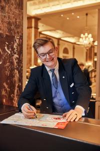 a man in a suit sitting at a table at Hotel Atlantic Hamburg, Autograph Collection in Hamburg