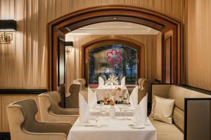 a dining room with a table and chairs and a mirror at Hotel Atlantic Hamburg, Autograph Collection in Hamburg