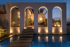 アムーダラ・イラクリオンにあるVaya Suites by Omilos Hotelsの夜間のスイミングプール付きのヴィラ