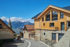 a wooden house on a street with mountains in the background at La Grange in LʼHuez