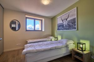 a bedroom with two beds and a window at La Grange in LʼHuez