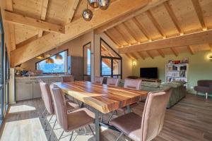 a kitchen and dining room with a wooden table and chairs at La Grange in LʼHuez