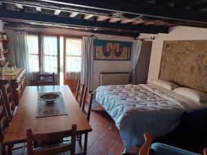 1 dormitorio con cama, mesa y sidx sidx sidx de mesa en LE PIANACCE - Appartamento per vacanze, en Castiglione di Garfagnana