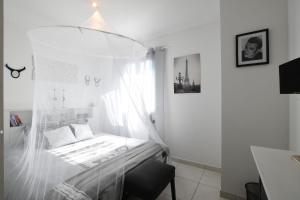 a bedroom with a bed with a mosquito net at Entre les Alpilles, la Mer, la Camargue, à huit kilomètres de ARLES ,Villa des jasmins ,piscine,3 chambres ,climatisation, wifi fibre in Raphèle +15 photos