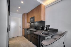 a kitchen with a counter and some chairs in it at Cannes Luxury Rental - Stunning apartment with terrace to rent Grand Hotel in Cannes