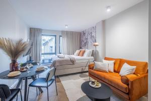 a living room with a couch and a bed at Flatbook - City Center Apartment Bank Polsk in Gdynia