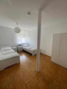 a white room with two beds and a pole at Ferienwohnung in Amstetten in Amstetten