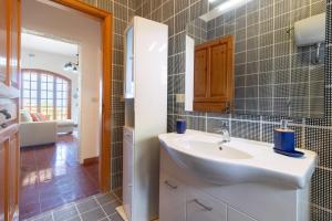 un baño con lavabo y espejo en Villa Serra, en Marina Serra 50 fotos más