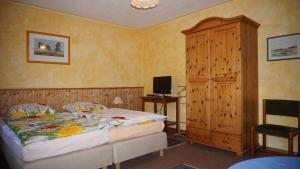 a bedroom with a bed and a wooden cabinet at Gaestehaeuser Eva_Maria und Reinha in Hinrichshagen Hof +49 photos