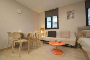 a living room with a bed and a table and a couch at 57 Hidden House BKK Chinatown in Bangkok