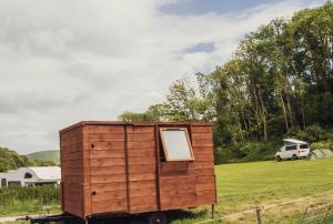 a wooden box on a trailer in a field at Leto Shepherds Hut By Airpremier in Alfriston