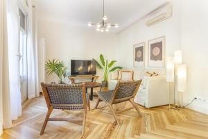 a living room with a table and chairs and a tv at Apartamento Retiro Place en Madrid in Madrid