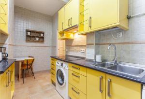 a yellow kitchen with a sink and a washing machine at Apartamento Retiro Place en Madrid in Madrid