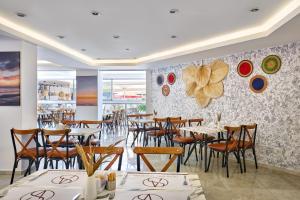 a restaurant with tables and chairs and a wall with plates at A Hotel Side in Side