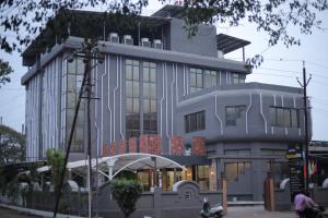a building with people sitting in front of it at Hotel Statusinn, Ichalkaranji in Ichalkaranji