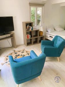 a living room with two chairs and a television at Gîte Studio Les Ecureuils in Narbonne
