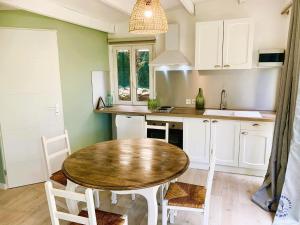 a kitchen with a wooden table and a table and chairs at Gîte Studio Les Ecureuils in Narbonne