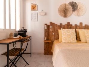 een slaapkamer met een bed en een bureau naast een bed bij La Casa del Burro in Nerja