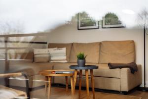 uma sala de estar com um sofá e duas mesas em Steilufer Appartments em Timmendorfer Strand
