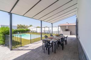 a patio with a table and chairs and a pool at Casa rural Villa Gordito in La Lantejuela
