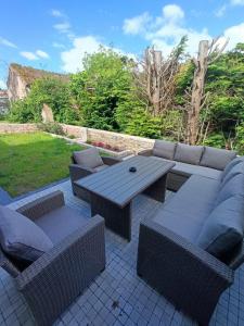 a patio with a picnic table and wicker chairs at Apartamentos Entrellusa - AT-1482-AS in Perlora