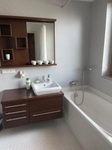 une salle de bain avec un lavabo et une baignoire dans l'établissement AJ Holiday - Władysławowo, à Władysławowo