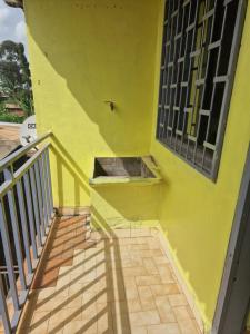 un bâtiment jaune avec un escalier et une fenêtre dans l'établissement Bel Appartement meublé à Bafoussam, à Bafoussam