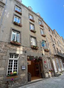 - un grand bâtiment en pierre avec des fenêtres et des plantes dans l'établissement Hotel des Abers, à Saint-Malo