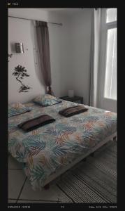 a bed with a colorful comforter in a bedroom at agnës in Limoux