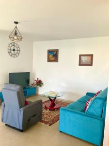 ein Wohnzimmer mit einem blauen Sofa und einem Tisch in der Unterkunft Manapany and Rose in Le Butor