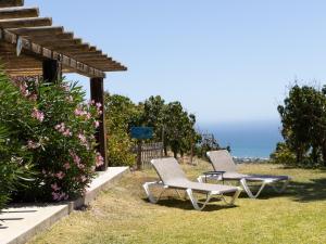 twee stoelen in het gras bij de oceaan bij La Casa del Burro in Nerja