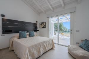 a bedroom with a bed and a couch and a window at Villa DEG Vista Mare San Teodoro Puntaldia in San Teodoro