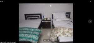 a bedroom with two beds and a chair at Wapda City Hotel in Faisalabad