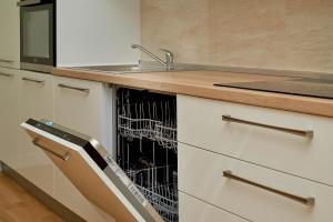 a kitchen with a sink and a dish drying rack at Skyline resort in Bečići