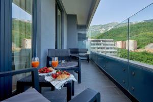 a balcony with two chairs and a table with fruit at Skyline resort in Bečići