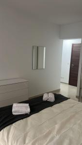 ムサイダにあるUBM Msidaの大きなベッドとタオル2枚のある寝室