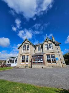 a large stone building with a blue sky in the background at Pitlochry Youth Hostel in Pitlochry