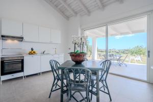 a kitchen and dining room with a table and chairs at Villa DEG Vista Mare San Teodoro Puntaldia in San Teodoro
