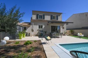 a house with a swimming pool in front of a house at Entre les Alpilles, la Mer, la Camargue, à huit kilomètres de ARLES ,Villa des jasmins ,piscine,3 chambres ,climatisation, wifi fibre in Raphèle