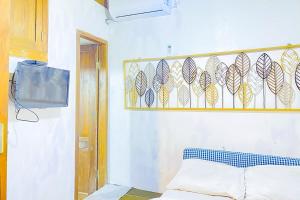 Habitación con cama y TV en la pared. en Lembah Mbalong Resort Mitra RedDoorz Near Exit Tol Singosari en Blimbing