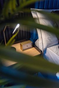 a small box on a night stand next to a bed at Glasswing Stays Margaret st, central Sheffield in Sheffield