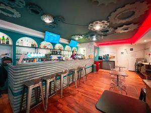 a bar in a restaurant with a person behind the counter at Ostello Bello Roma Colosseo in Rome +46 photos