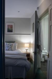 - une chambre avec un lit, une lampe et une porte dans l'établissement The Rookery Cottage - Newland, à Newland