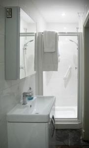 une salle de bain blanche avec un lavabo et une douche dans l'établissement The Rookery Cottage - Newland, à Newland
