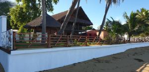 ein Resortgebäude mit einem Zaun am Strand in der Unterkunft Lodge Villa MAYANKI in Dzamandzar