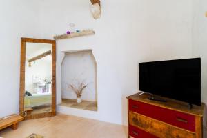 a living room with a tv and a mirror at L'angolo Fiorito in Ugento